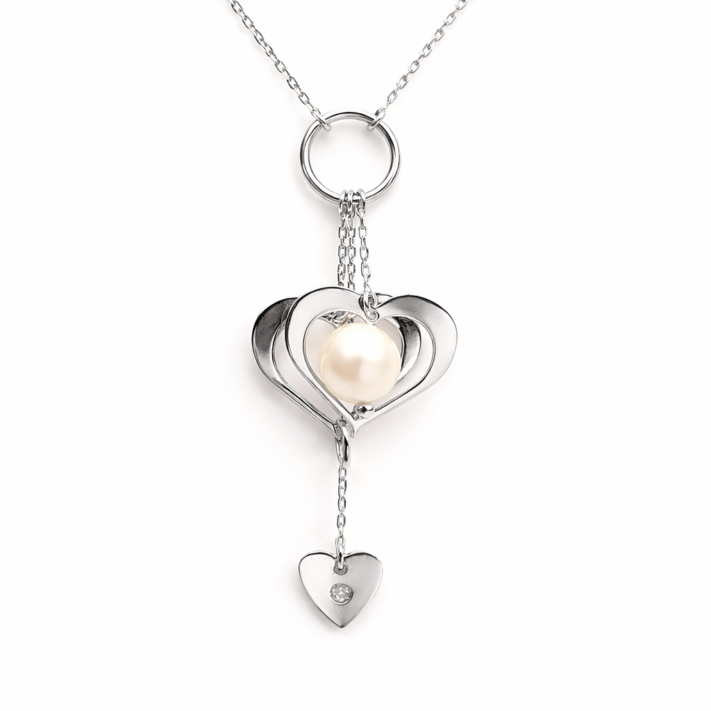 Détail du pendentif cœurs en or blanc 750 avec perle blanche et pampille cœur ornée d'un oxyde de zirconium.