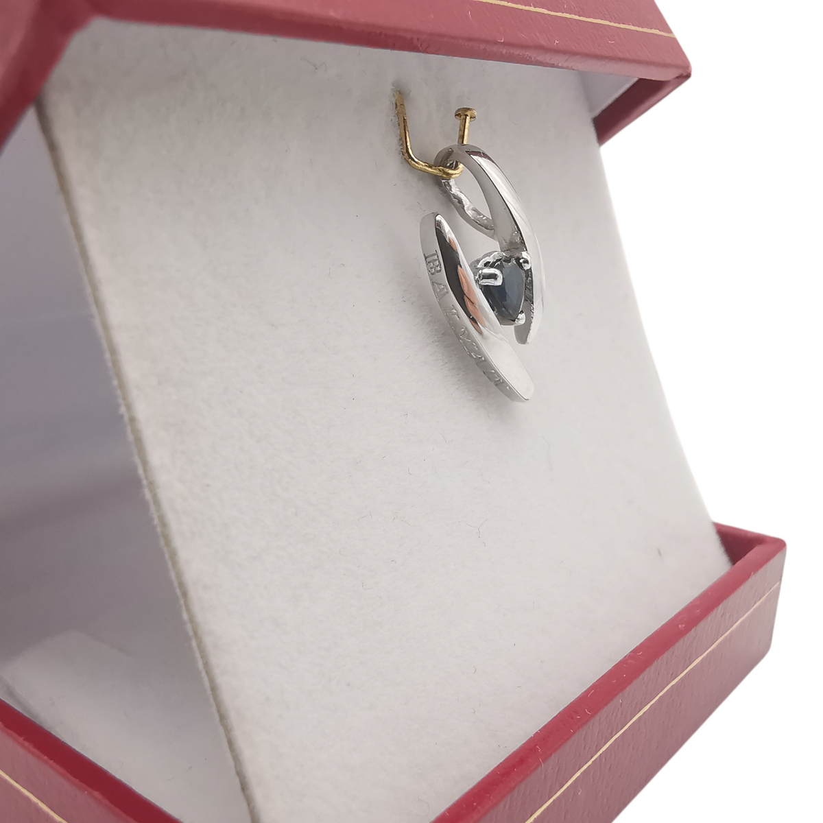Vue de profil du pendentif BALMAIN en or blanc et saphir bleu.