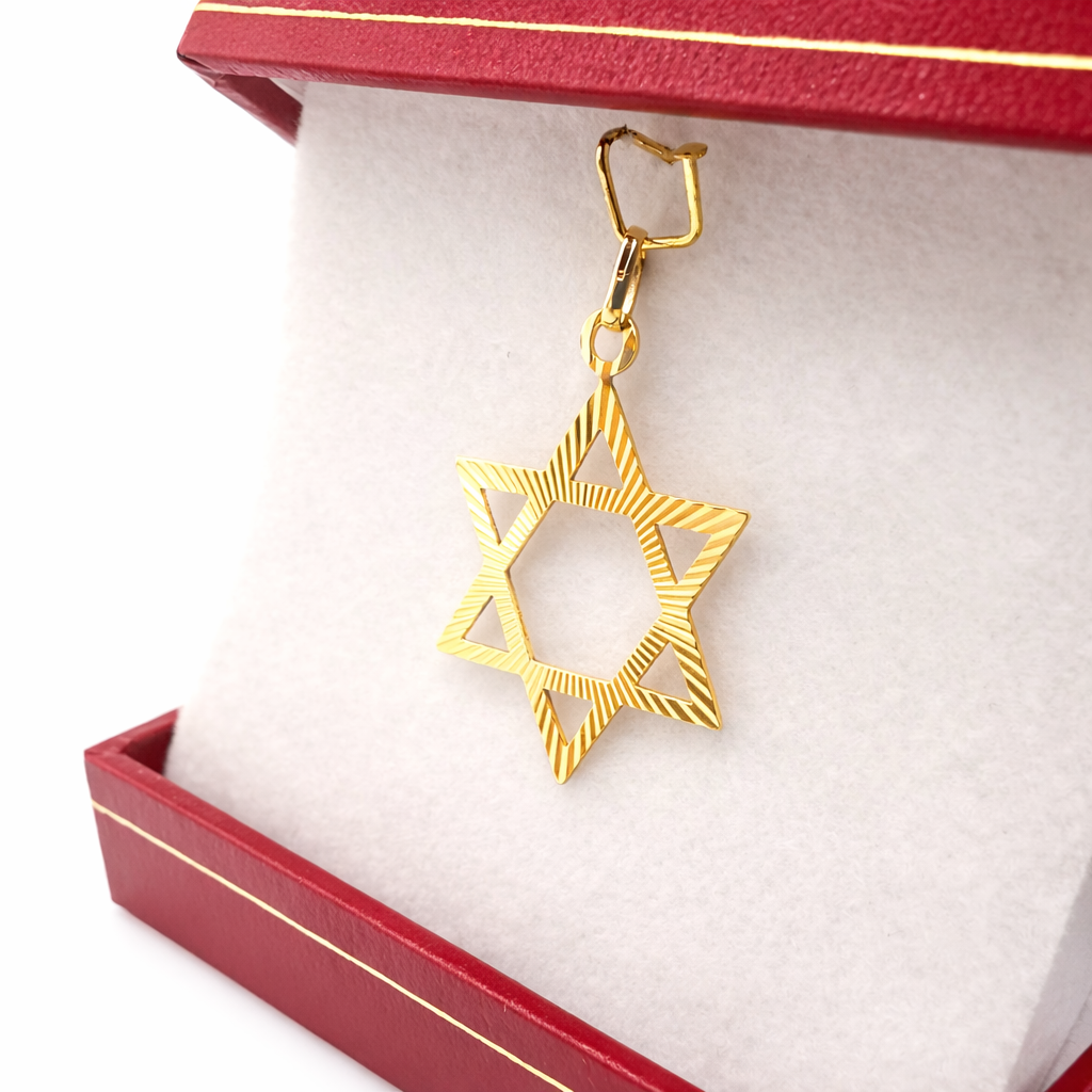 Pendentif Étoile de David en or jaune 750, suspendu dans un écrin rouge, finition gravée et ajourée.