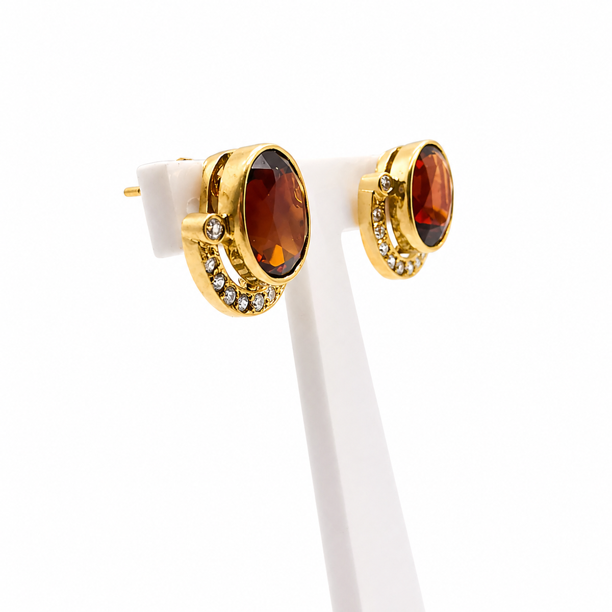 Vue de trois quarts des boucles d'oreilles en or jaune serties de grenats et diamants.
