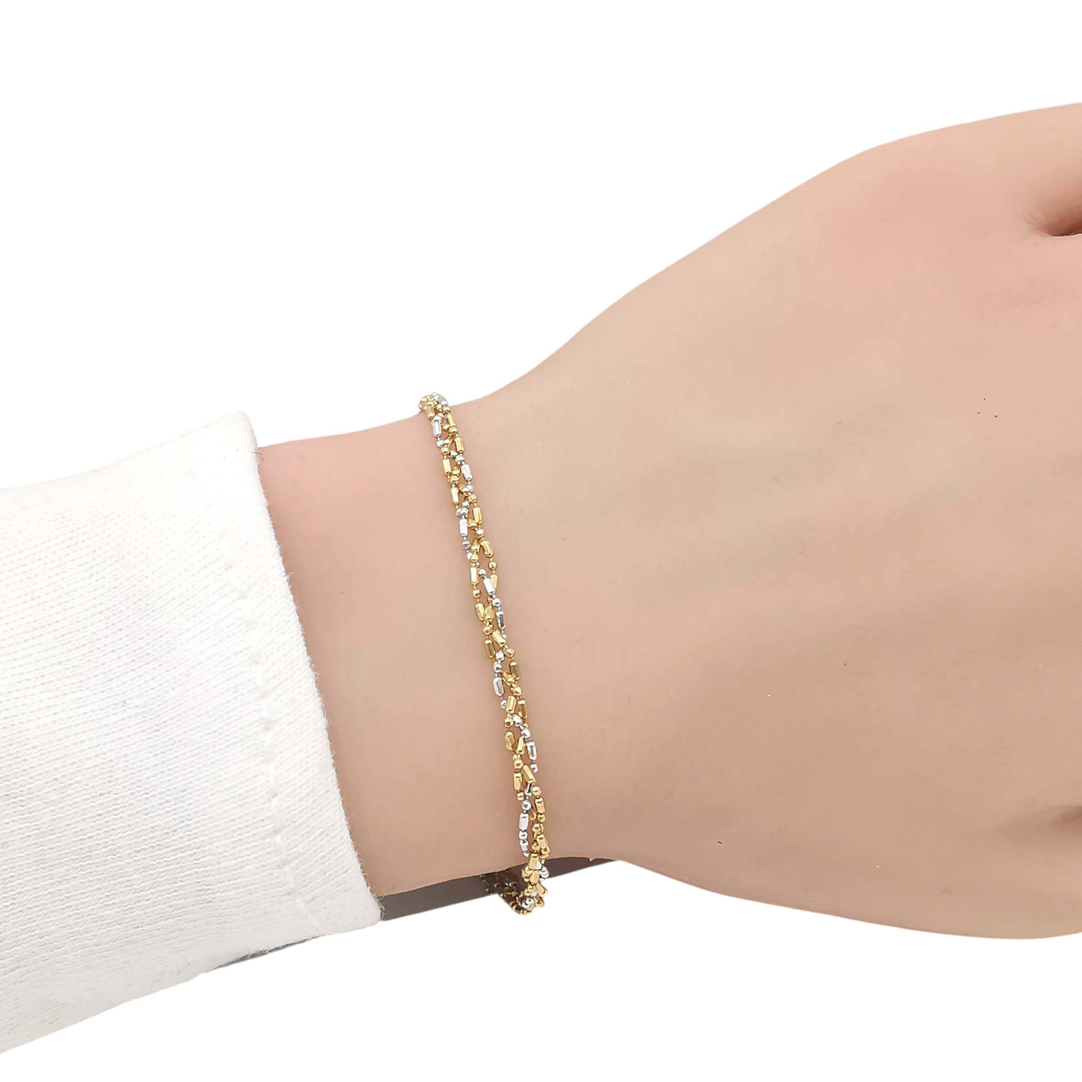 Poignet portant un bracelet maille fantaisie bicolore en or jaune et or blanc 18 carats