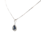 Vue rapprochée du collier saphir bleu et diamants monté sur chaîne en or blanc.