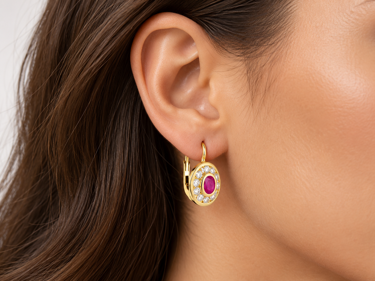 Boucle d'oreille dormeuse en or jaune 18 carats portée à l'oreille, modèle ovale avec pierre rose centrale.