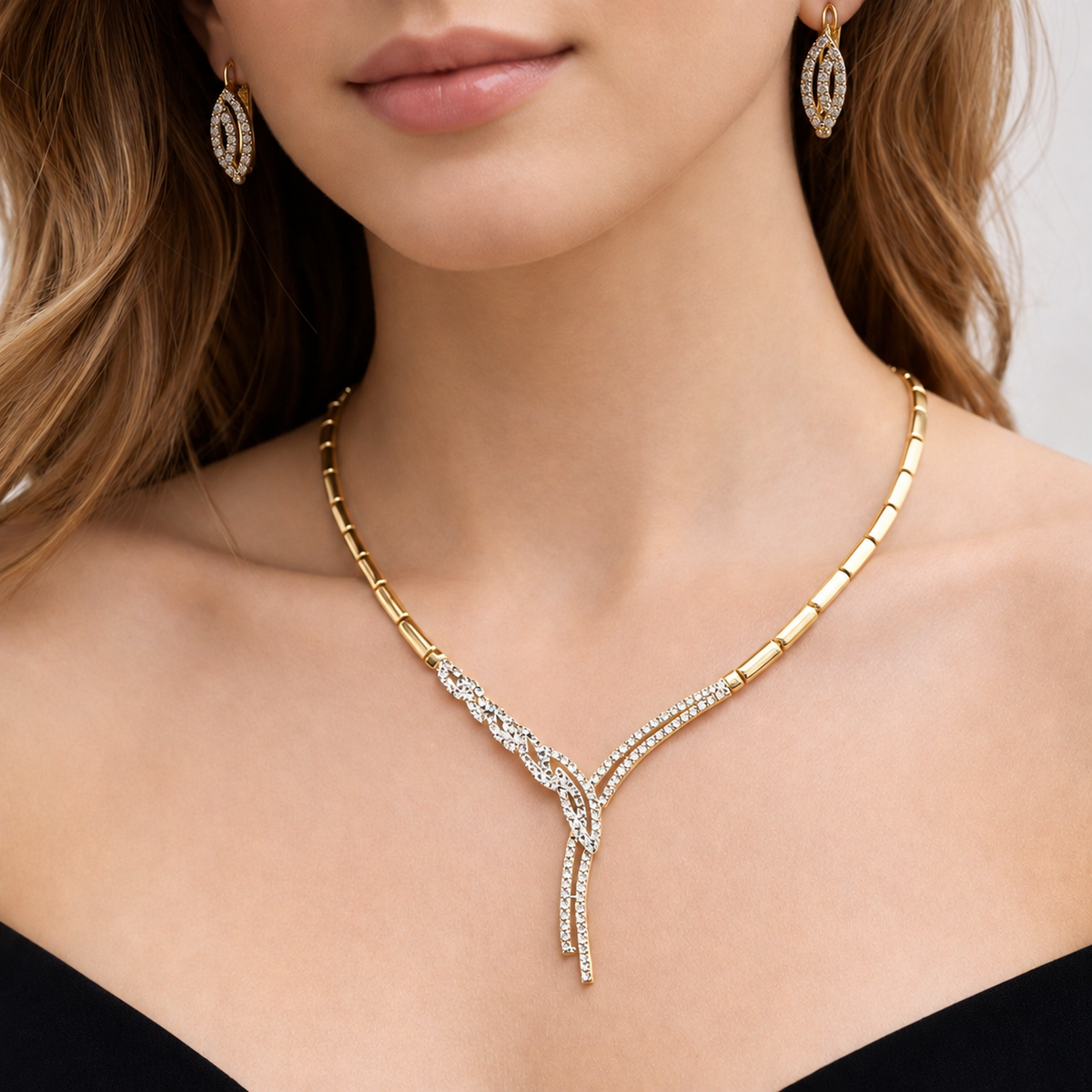 Parure en or jaune 18 carats avec collier et boucles d'oreilles en oxydes de zirconium portée par une femme
