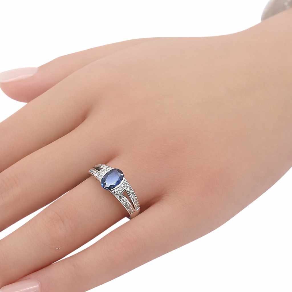 Bague saphir bleu ovale et diamants en or blanc 18 carats portée au doigt, vue de trois quarts