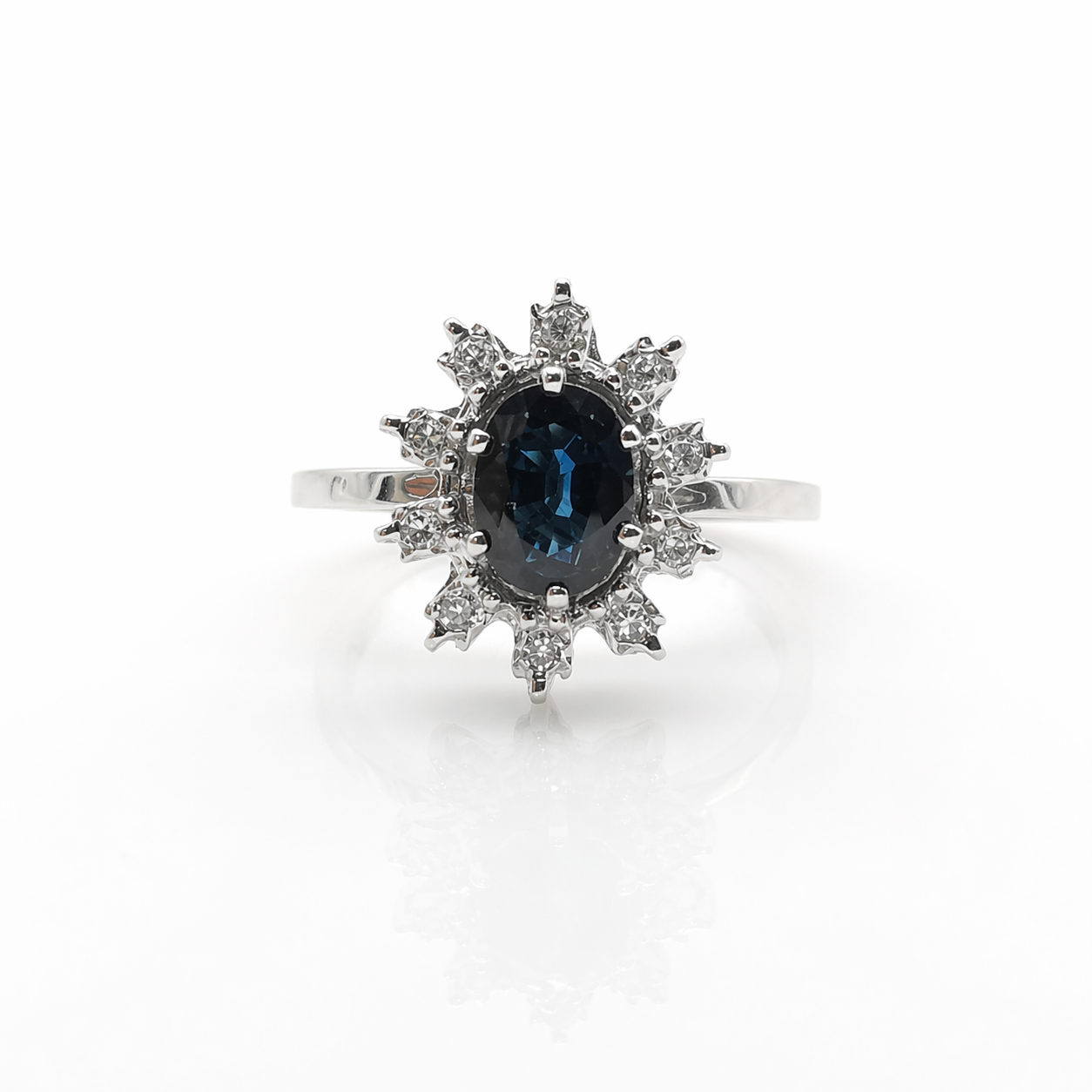 Bague marguerite en or blanc 18 carats sertie d'un saphir naturel ovale de 1,20 carat entouré de diamants naturels taille brillant, proposée par GemmeLuxe.