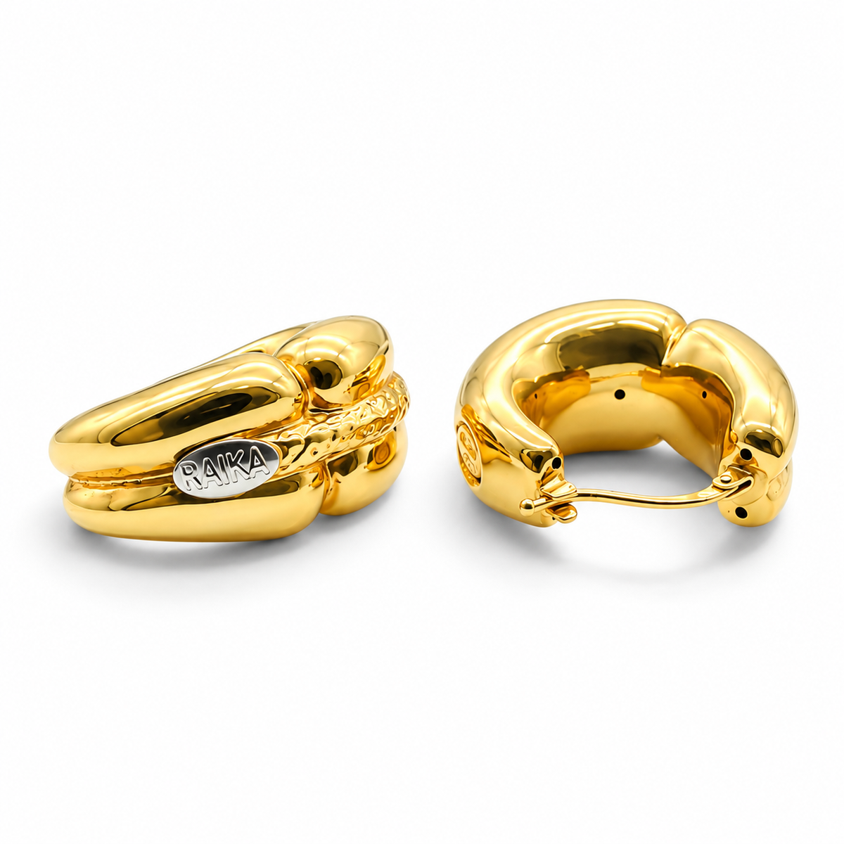 Boucles d’oreilles RAIKA en or jaune 18K présentées sur support, signature visible
