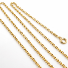 Gros plan des maillons et du fermoir anneau ressort d'une chaîne en or jaune 18 carats.