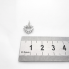 Pendentif cœur en or blanc 18 carats et diamants photographié avec une règle graduée.