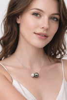 Femme portant un collier signé Guérin en or blanc 18 carats avec perle de Tahiti grise et perle blanche