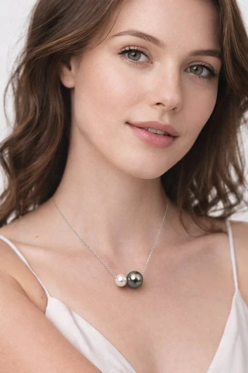 Femme portant un collier signé Guérin en or blanc 18 carats avec perle de Tahiti grise et perle blanche