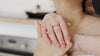 Mains d’une femme portant une bague sertie d’un diamant et un bracelet fin