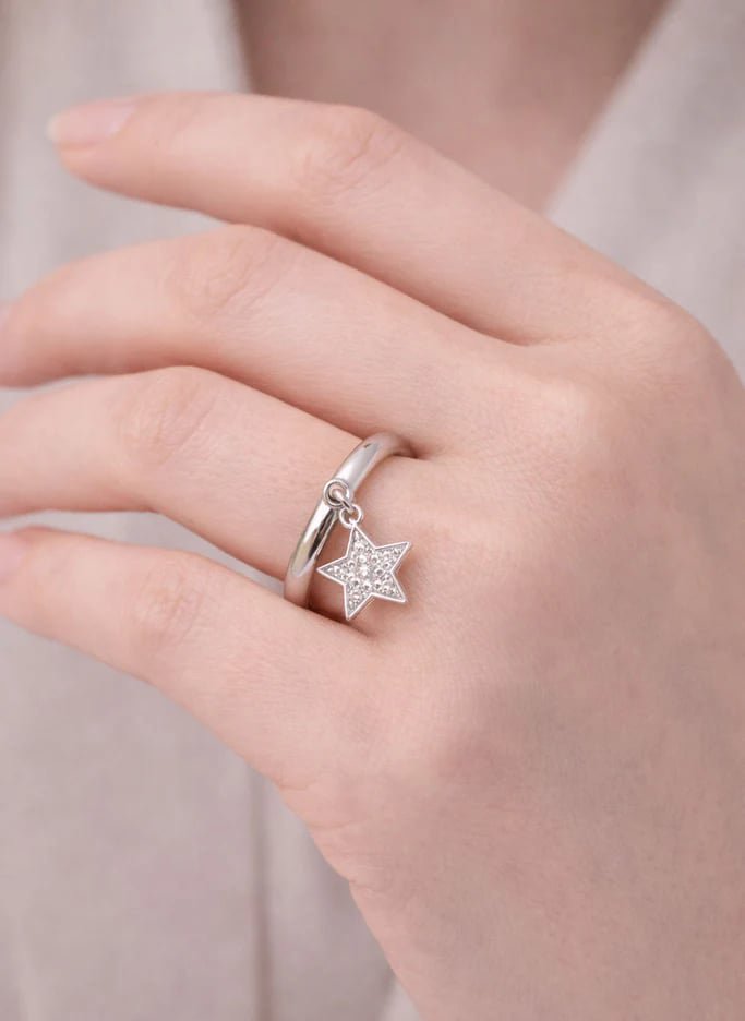 Main portant une bague avec pendentif étoile serti de diamants