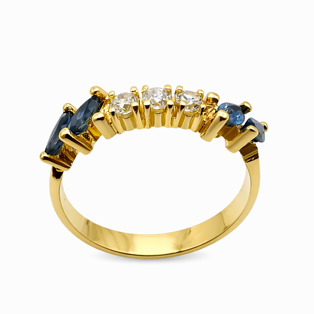 Vue de profil d'une bague ancienne en or jaune 18 carats montrant le sertissage à griffes des saphirs et diamants