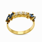 Vue de profil d'une bague ancienne en or jaune 18 carats montrant le sertissage à griffes des saphirs et diamants